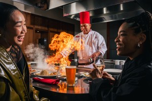 a chef standing next to a woman and a man in a restaurant