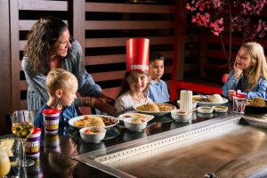Kids wearing chef hats and celebrating a birthday with Hibachi food